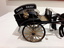 A model of a horse drawn black open Davis Dairy Buggy or Cart used to deliver milk in the late 1800's and early 1900's.