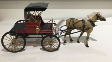 A model of a red and black Piano Box Buggy which was a lightweight two wheeled one passenger open horse drawn carriage.