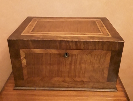 A rectangular handmade lidded wooden box with inlaid patterned wood panels on each side and the lid.