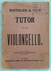 A pink covered paperback Tutor Book for the Violoncello.