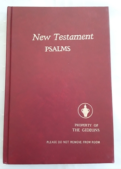 A red covered slim book of The New Testament and Psalms.