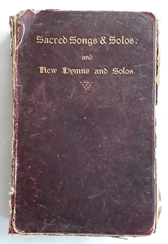 A thick burgundy hardcover book with the title printed in gold lettering at the top of the front cover  