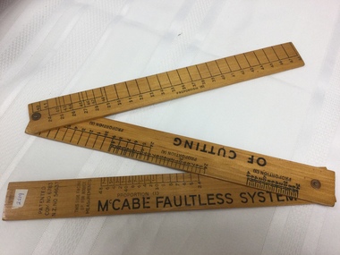 A McCabe faultless system of cutting dressmakers folding wooden ruler. 