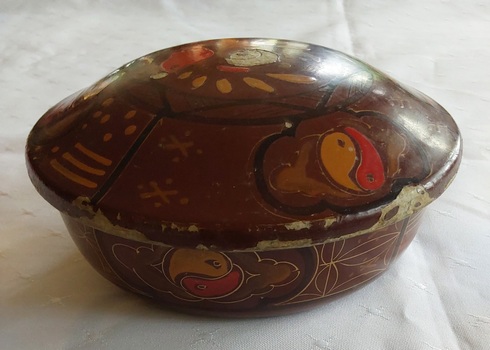 A decorated brown lidded round container coated inside with black and brown type lacquer. 