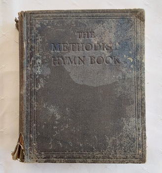 A faded and damaged black fabric covered Methodist Hymn Book for Use in Australasia and New Zealand.