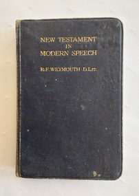 A small black hardcover book of The New Testament in Modern Speech.