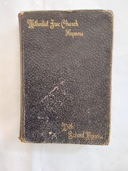 A badly damaged black miniature leatherette softcover book, Methodist free Church Hymns with School Hymns. 