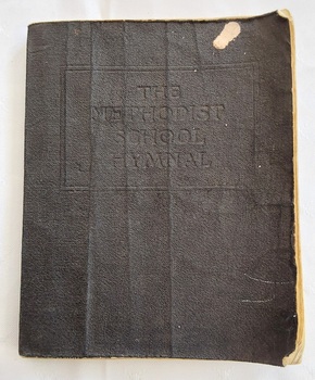 A thin black paperback vinyl covered vintage copy of The Methodist School Hymnal.