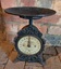 An antique footed ornate black cast metal Salter brand kitchen scale from the Victorian era. 