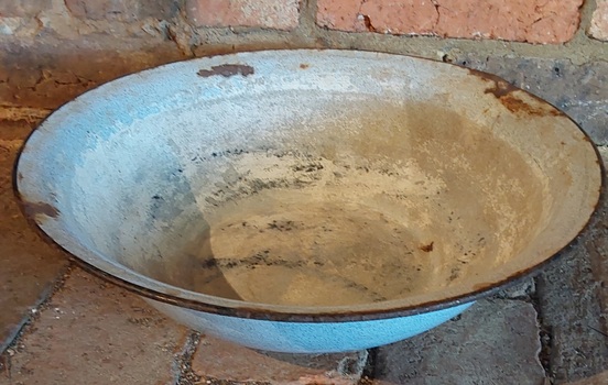 A badly damaged vintage large pale blue round enamel bowl.