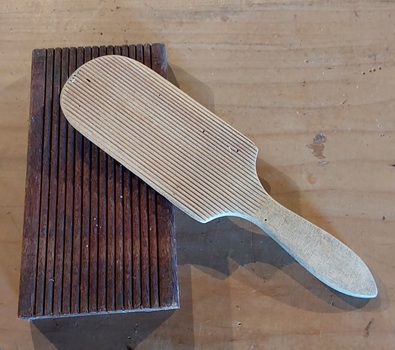 Two vintage wooden butter pats with ribs on one side for the butter to be shaped.