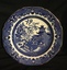 A blue and white Willow Pattern scalloped edged butter plate with a fine gold line around the outer edge.