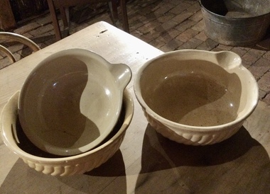 Three vintage different sized cream coloured stoneware mixing bowls with a pouring lip for cooking. 