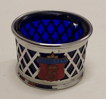 A small vintage chrome plated mustard pot with a basket weave outer container and a cobalt blue glass insert.