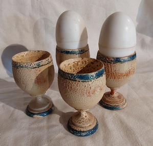 Four vintage badly crackled white wooden egg cups with dark green stripes at the rim and base of stems. 