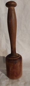 A long handled wooden vintage meat mallet with a knob on the handle and a thick mallet shape at the bottom.