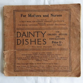 A slim brown badly damaged paperback book with the title, Dainty Dishes for Children, Invalids and Convalescents.