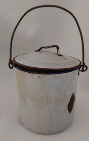 A small rusted and chipped lidded can or billy with a wire handle looped at the sides.