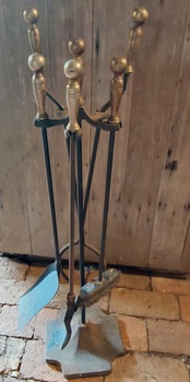 A 20th century set of four wrought iron fire irons hanging on a heavy steel base square stand with the main rod riveted to the base. 