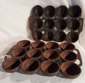 Two vintage heavy cast iron gem scone tins or trays one slightly larger than the other.