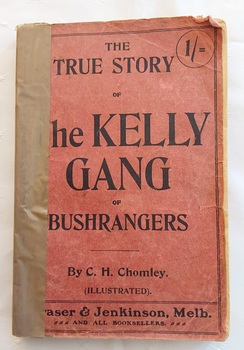 A small faded red book titled: The True Story of the Kelly gang of Bushrangers by C.H. Chomley with publisher details at the bottom.