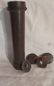 An incomplete rusted long tubular tin cookie or icing press with four pattern attachments. 