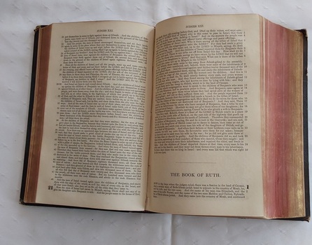 An olive green hardcover Holy Bible, Authorized Version of the New and Old Testaments with a wide brown band at the edge next to the spine and triangular corners on the right edges.
