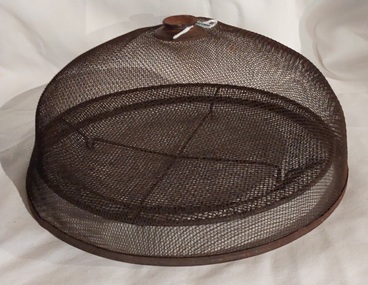 A rusted vintage wire mesh domed food cover or cloche with a rounded flat knob or handle at the top. 