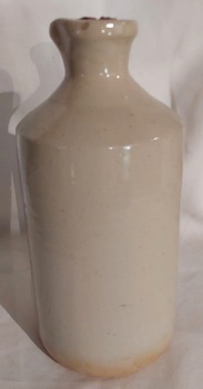 A medium sized vintage cream coloured glazed stoneware bottle with a pouring lip and broken cork stopper.