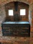 A vintage cast iron kitchen stove set in the back wall of the Mont De Lancey Slab Kitchen.