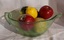 A vintage large round green Depression glass mixing bowl with a pouring lip and handle, used for cooking.