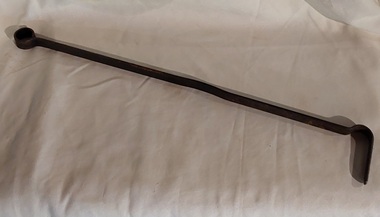 A long steel vintage fire poker with a small finger loop at the end of the handle and a bent hook shape at the end.