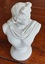 A small white resin or plaster Apollo Bust Statue which embodies beauty, music, and prophecy. 