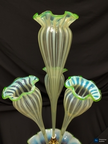 Clouded green striped glass fruit bowl with ruffle/scallop edge, three flutes attached going upwards at a diagonal and one larger flute in middle going upwards