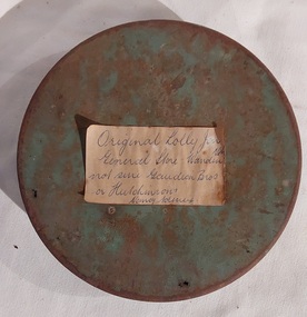 A large blue/green tin lid from a lolly jar. 