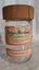 A clear glass jar for English Marmalade with a cracked brown wooden screw-top lid. 