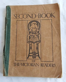 A very damaged brown softcover book with the title, Second Book of the Victorian Readers printed in black lettering on the front cover.