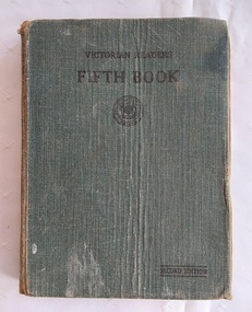 A faded dark green fabric covered hardcover with the title Victorian Reader Fifth Book printed in black lettering at the top of the front cover.