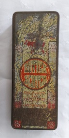 A rusty empty vintage small rectangular metal red and gold tin with faded branding on the lid. It contained Butter Scotch sweets. 