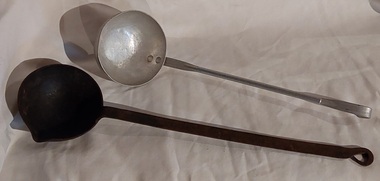 Two soup ladles for kitchen use - one is aluminium, the other is cast iron.