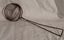 A vintage wire cooking strainer or ladle with an open wire scoop.