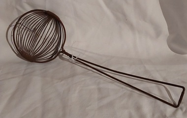 A vintage wire cooking strainer or ladle with an open wire scoop.