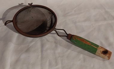 A vintage wooden handled wire mesh flour sieve or sifter with two small metal supports to rest on a bowl at the top.