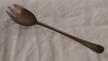 A vintage silver plated hand salad server fork with a long lined patterned handle finishing with a crest.