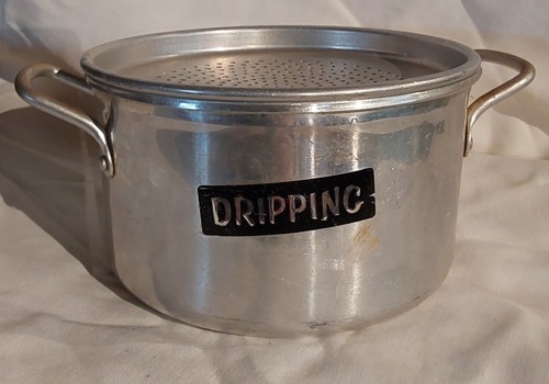 An aluminium dripping container with two side handles at the top of the rim and a removable strainer with holes. No lid.