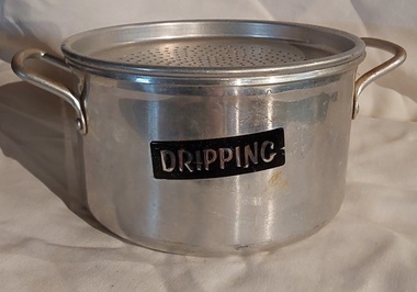 An aluminium dripping container with two side handles at the top of the rim and a removable strainer with holes. No lid.