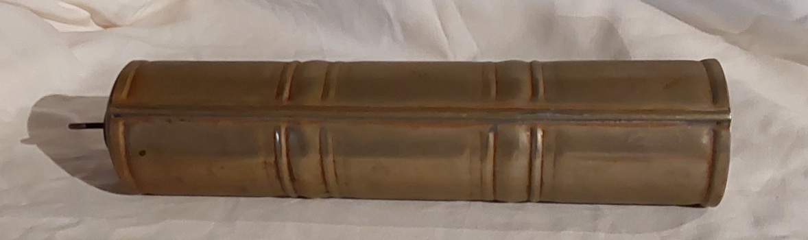 A long vintage gold painted aluminium, cylindrical bed or foot warmer, with a removable brass screw stopper which has a looped handle on top.