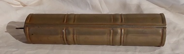 A long vintage gold painted aluminium, cylindrical bed or foot warmer, with a removable brass screw stopper which has a looped handle on top.