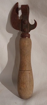 A dual metal can and bottle opener with a decorative line on the turned wooden handle. 