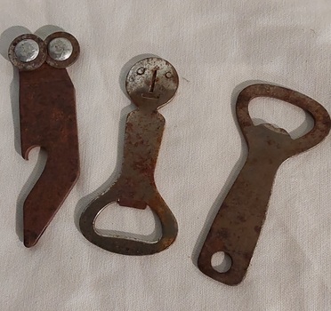 Three small rusted vintage metal bottle openers.